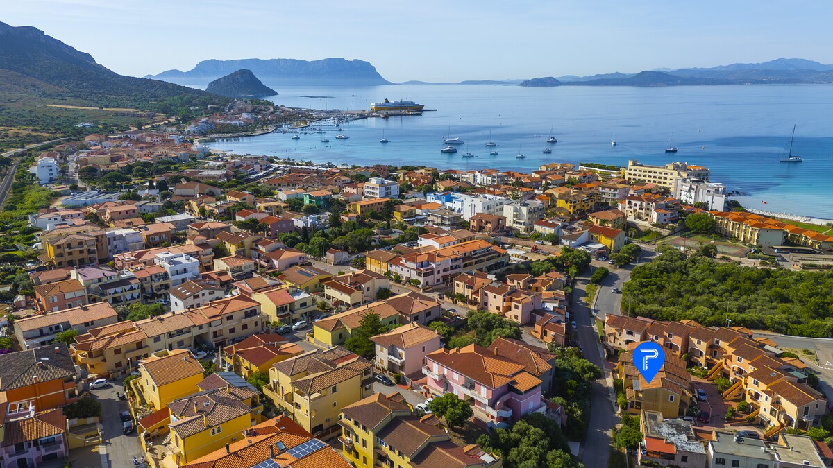 Il centro di Golfo Aranci con le case colorate e il mare turchese, borgo marinaro della Gallura